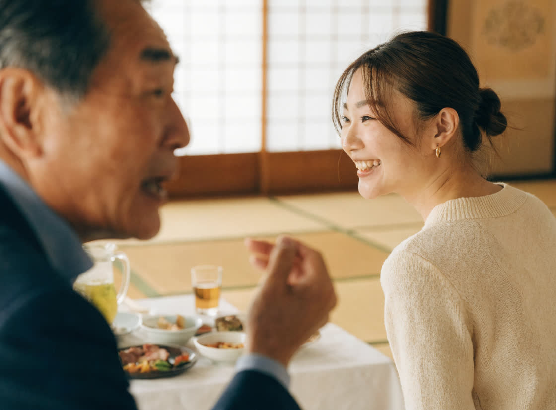 座敷で、話しているお客様のほうを向いて笑っている女性